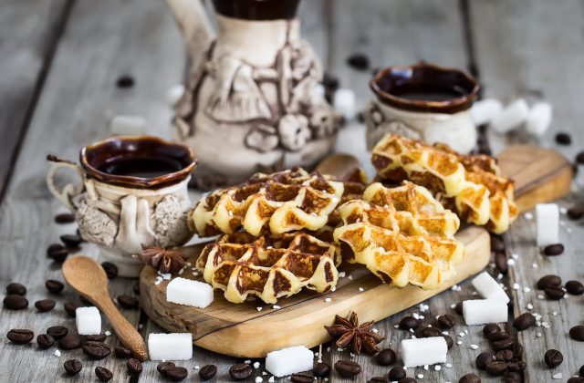 Homemade liege belgian waffers with sugar pearls and coffee on old wooden background